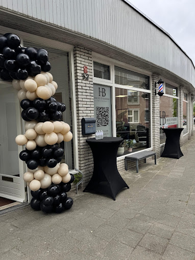 Buitenkant van House of Barbers Enschede met ballondecoratie en barberpaal aan de Gronausevoetpad